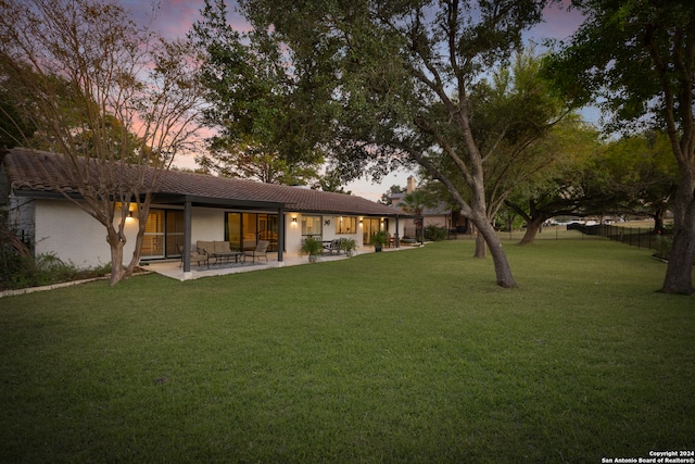 yard at dusk featuring a patio