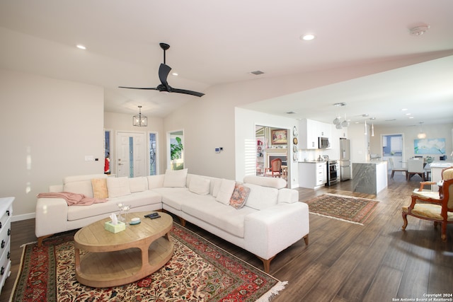 living room with dark wood-type flooring, ceiling fan, and vaulted ceiling