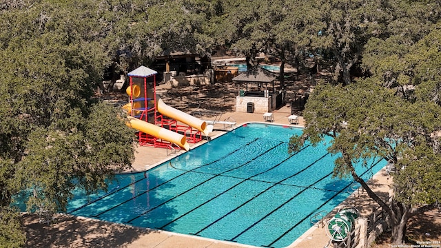 view of swimming pool featuring a gazebo, a water slide, a playground, and a patio