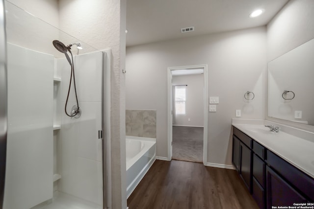 bathroom with wood-type flooring, vanity, and a bathtub