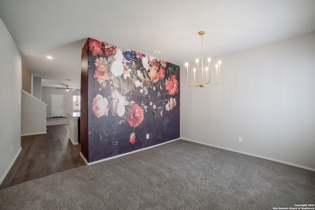 unfurnished room with dark colored carpet and ceiling fan with notable chandelier