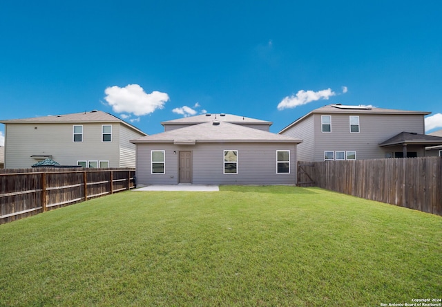 rear view of house featuring a lawn and a patio area