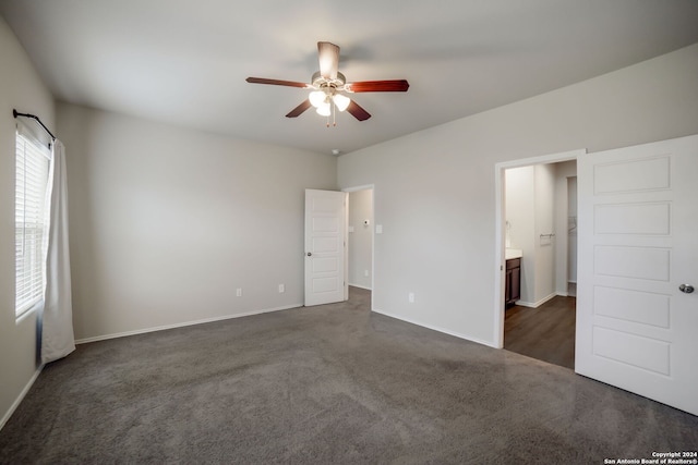 unfurnished bedroom featuring connected bathroom, ceiling fan, and dark colored carpet