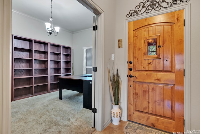 carpeted foyer entrance featuring ornamental molding and an inviting chandelier