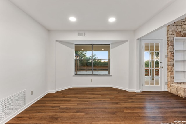 unfurnished dining area featuring a wealth of natural light and dark hardwood / wood-style floors