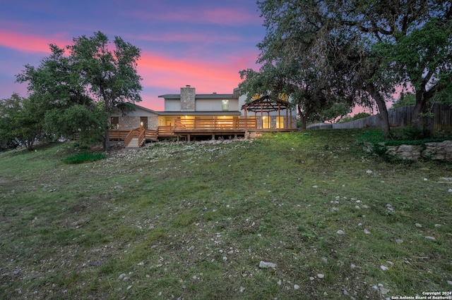 yard at dusk with a gazebo and a wooden deck