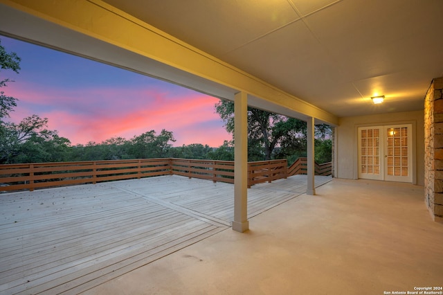 patio terrace at dusk with a wooden deck and french doors