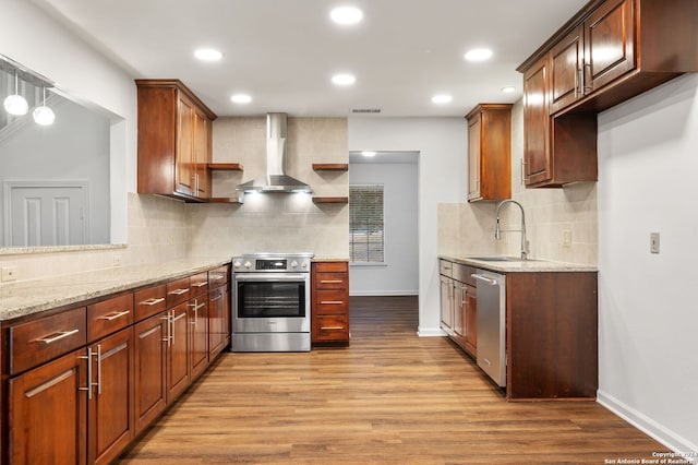 kitchen with wall chimney range hood, light hardwood / wood-style flooring, stainless steel appliances, backsplash, and sink