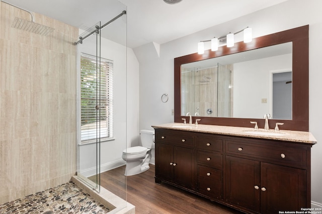 bathroom with vanity, toilet, a shower with shower door, and hardwood / wood-style floors