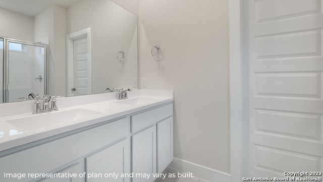 bathroom with a stall shower and double vanity