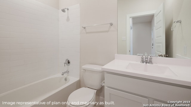 full bathroom featuring tiled shower / bath, vanity, and toilet