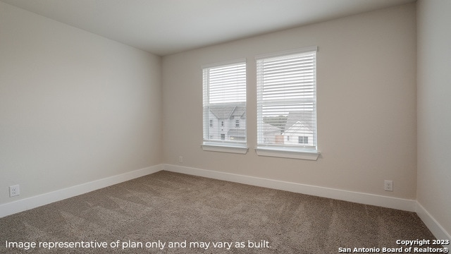 carpeted spare room with baseboards