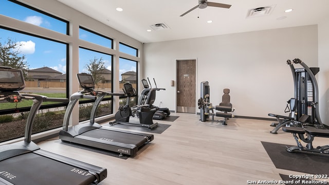 exercise room featuring recessed lighting, a ceiling fan, wood finished floors, and baseboards