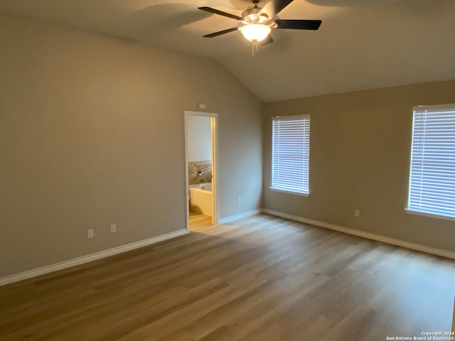 unfurnished room featuring hardwood / wood-style floors, ceiling fan, plenty of natural light, and vaulted ceiling