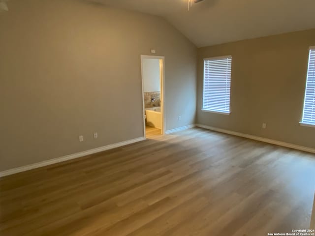 spare room featuring light hardwood / wood-style floors, lofted ceiling, and ceiling fan