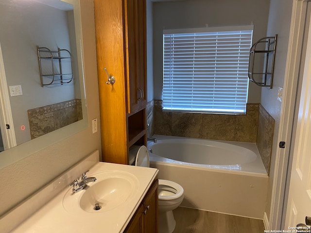 bathroom featuring vanity, a tub to relax in, toilet, and hardwood / wood-style floors