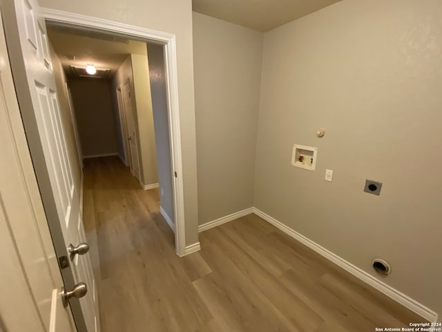 washroom with light hardwood / wood-style floors, washer hookup, hookup for an electric dryer, and hookup for a gas dryer