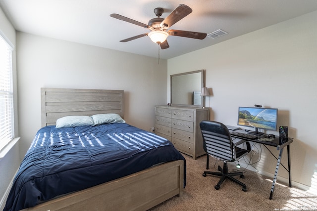 bedroom with light colored carpet, multiple windows, and ceiling fan