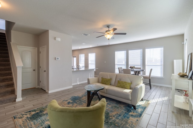 living room featuring light hardwood / wood-style flooring and ceiling fan