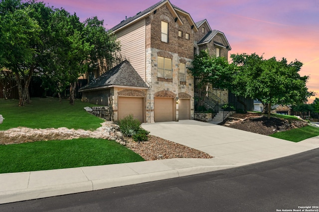 view of front of house featuring a yard and a garage