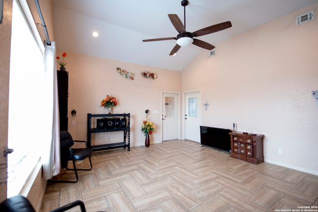 sitting room with high vaulted ceiling, light parquet flooring, and ceiling fan