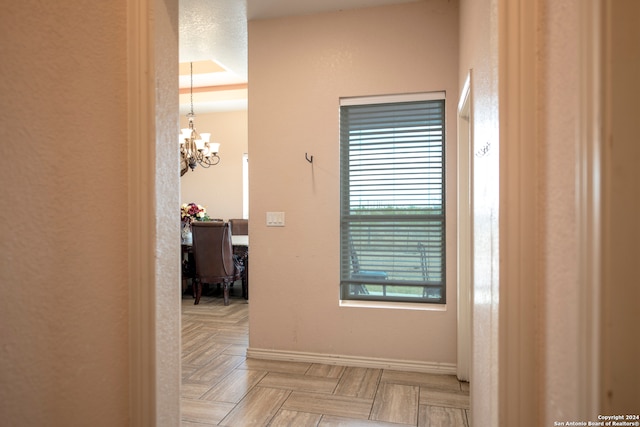 hall featuring a notable chandelier and light parquet flooring