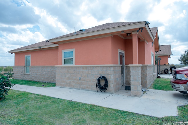 view of home's exterior with a patio and a lawn