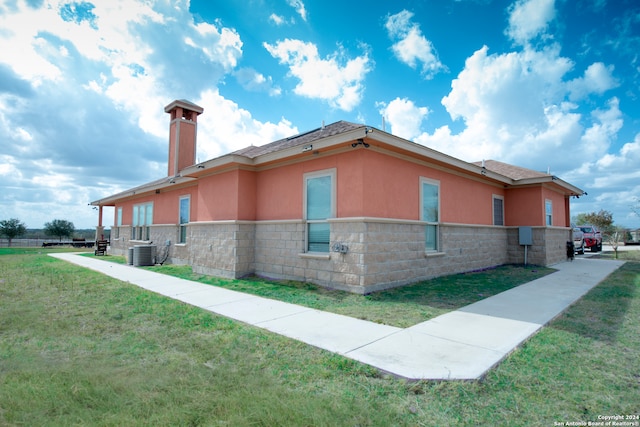 view of side of property with a lawn and cooling unit