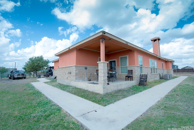 view of side of home featuring cooling unit and a yard