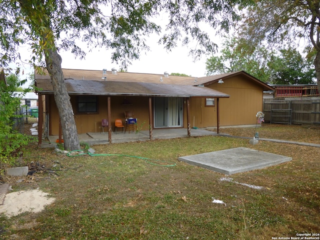 back of property with a lawn and a patio area