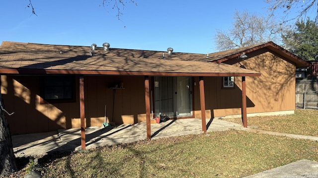 back of property featuring a lawn and a patio