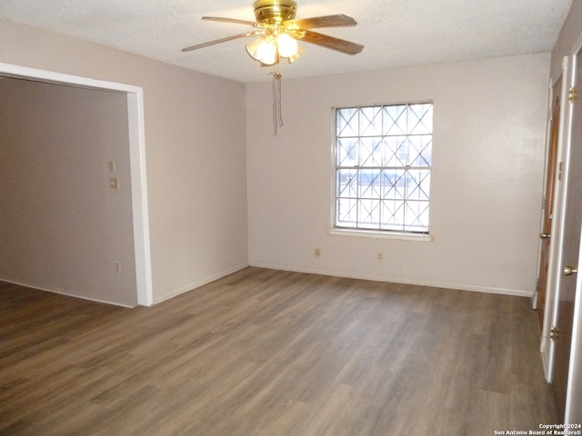 spare room with a textured ceiling, dark hardwood / wood-style floors, and ceiling fan