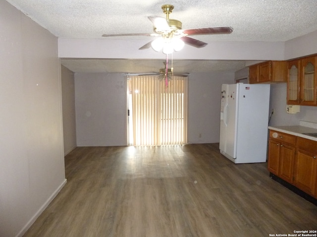 kitchen with a textured ceiling, white fridge with ice dispenser, dark wood-type flooring, and ceiling fan