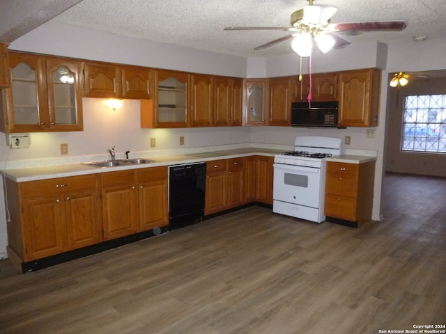 kitchen with dark wood-type flooring, sink, black appliances, and a textured ceiling