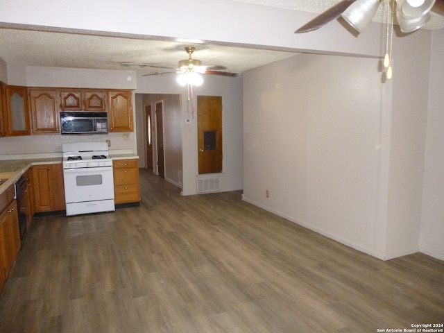 kitchen with dark wood-type flooring, black appliances, and a textured ceiling