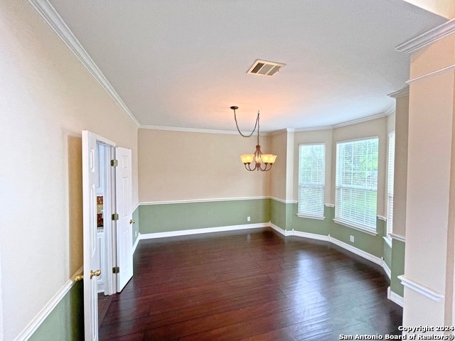 unfurnished room with ornamental molding, a notable chandelier, and dark hardwood / wood-style flooring