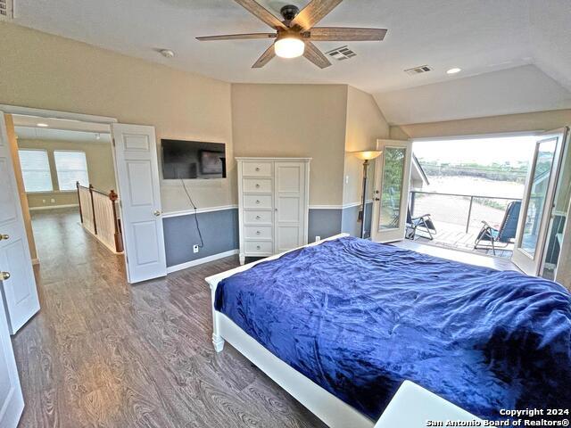 bedroom with multiple windows, access to exterior, wood-type flooring, and ceiling fan