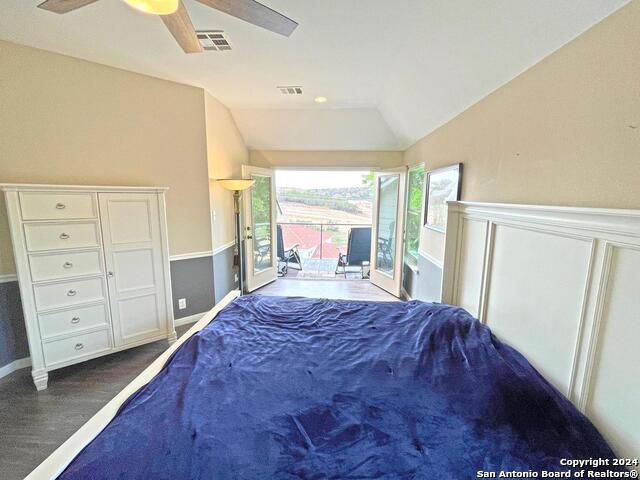 bedroom featuring lofted ceiling, dark wood-type flooring, access to exterior, and ceiling fan