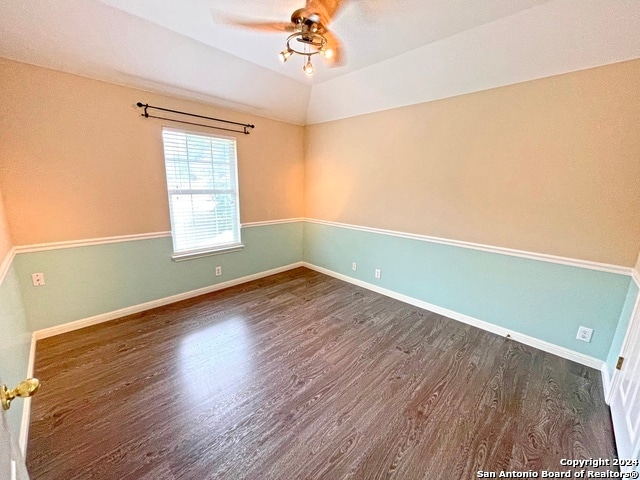 empty room featuring dark wood-type flooring, ceiling fan, and lofted ceiling