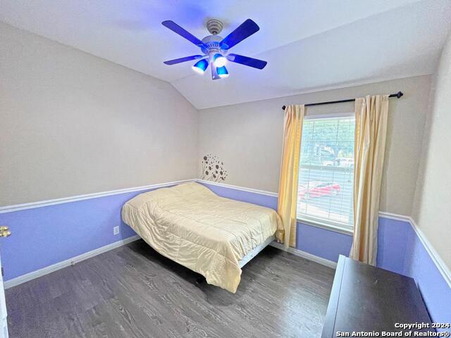 bedroom featuring ceiling fan, vaulted ceiling, and dark hardwood / wood-style flooring