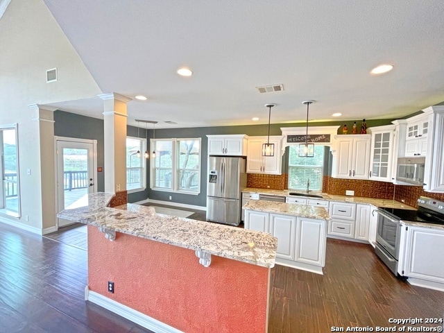 kitchen featuring sink, a center island, stainless steel appliances, white cabinets, and dark hardwood / wood-style floors