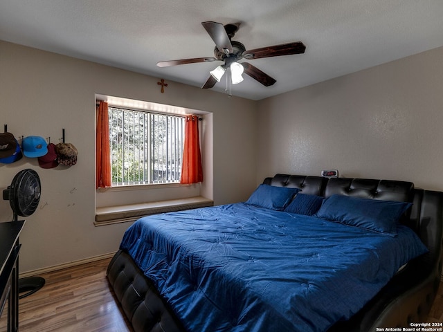 bedroom featuring hardwood / wood-style floors, a textured ceiling, and ceiling fan