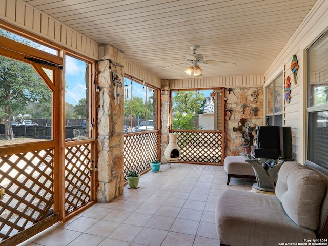 sunroom with ceiling fan and wooden ceiling