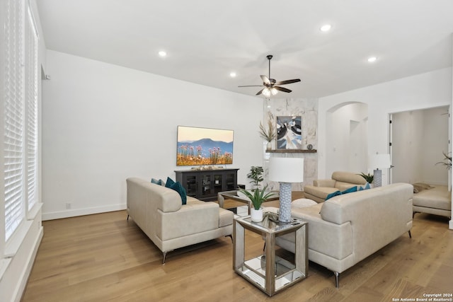 living room featuring light hardwood / wood-style flooring and ceiling fan