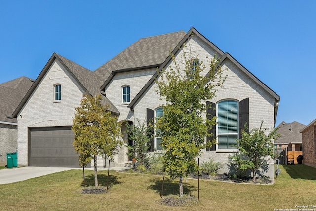 french country inspired facade featuring a front yard and a garage