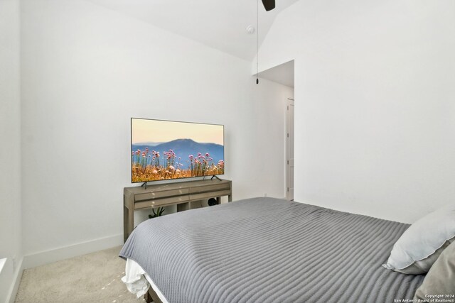 carpeted bedroom featuring ceiling fan and vaulted ceiling