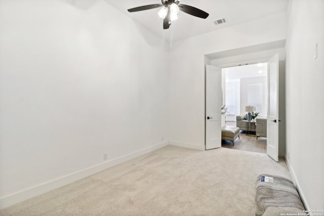 spare room featuring light carpet and ceiling fan