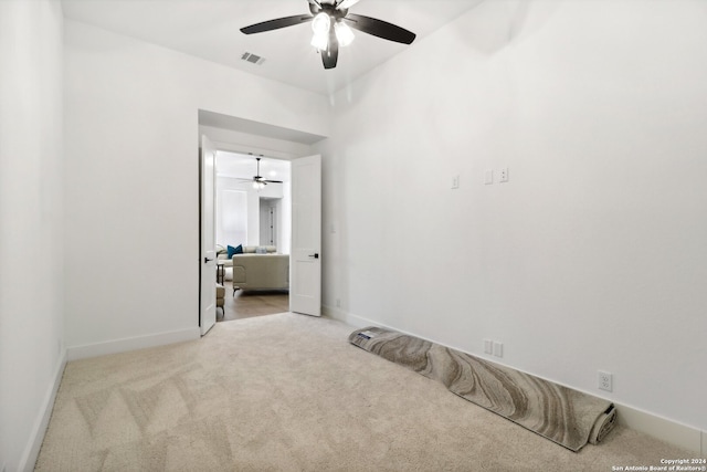 unfurnished bedroom featuring light carpet and ceiling fan