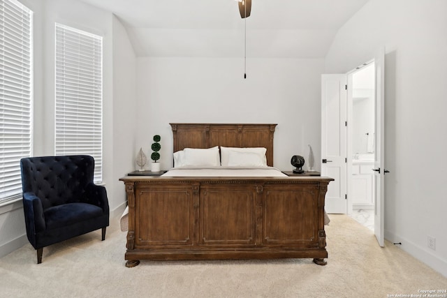 carpeted bedroom with ceiling fan, ensuite bath, and vaulted ceiling