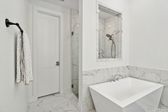 bathroom featuring plus walk in shower and tile walls